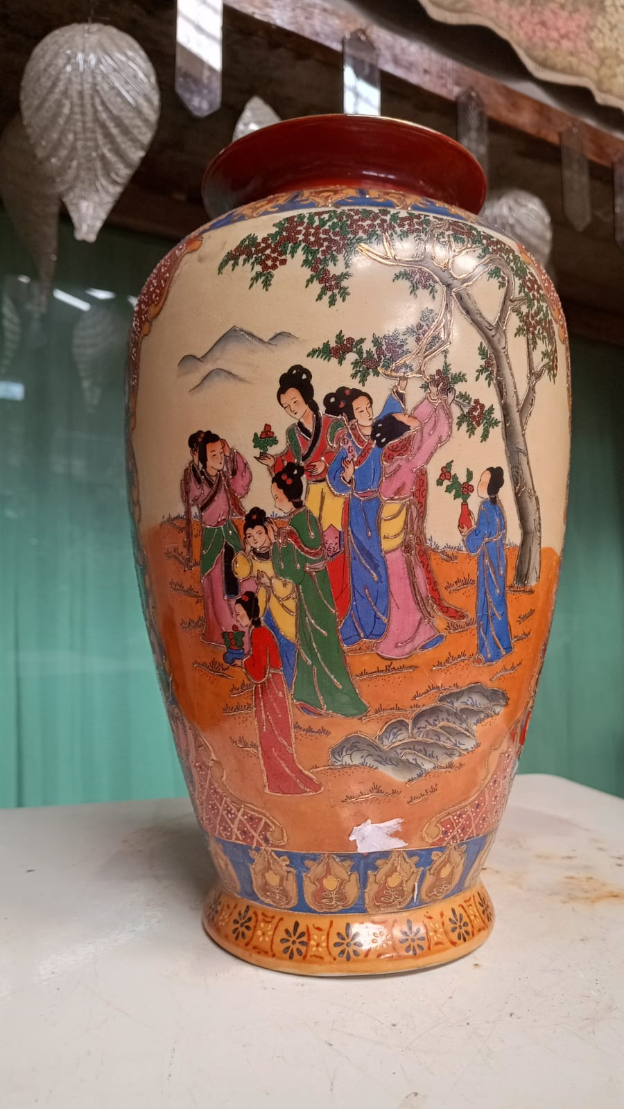 Vaso oriental decorado com figuras em vestes coloridas e paisagem